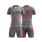 Gri, siyah desenli, kırmızı detaylara sahip futbol forması.